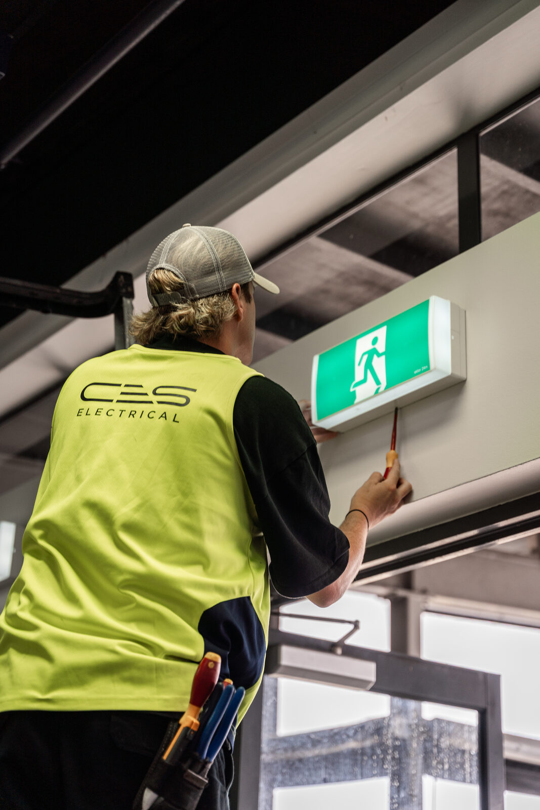 CES Electrical technician installing emergency exit lighting