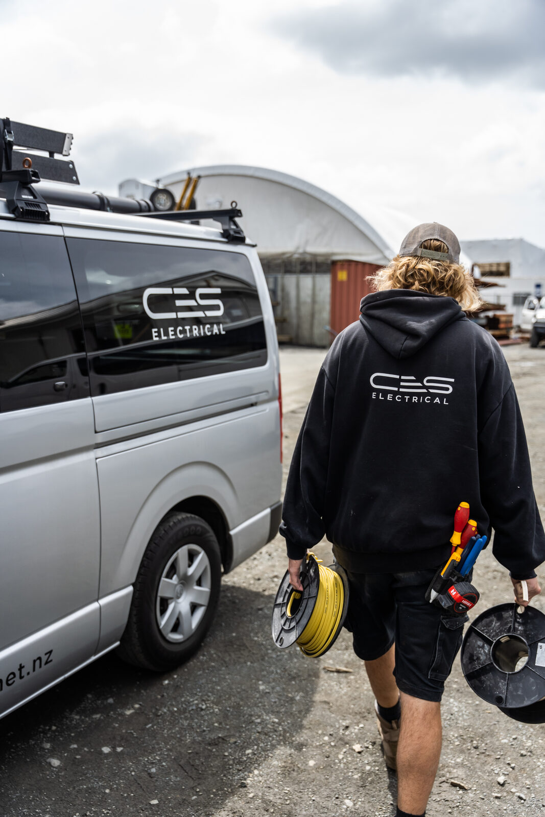 CES Electrical technician carrying cable reels